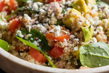 Close-up of a vibrant and nutritious salad made with quinoa, avocado, mixed seeds, and cheese, packed with protein and healthy fats for a wholesome meal