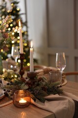 Christmas place setting with festive decor on wooden table in room