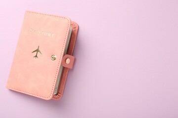 Passport in pink cover on violet background, top view. Space for text