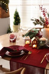 Christmas table setting with stylish dishware and festive decor indoors