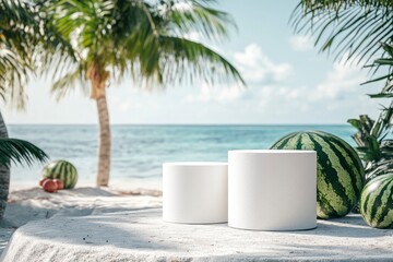 Obraz premium A mockup of two white cylindrical pedestals placed on the beach, with watermelons and palm trees in the background, and an ocean view. It exudes a summer vibe.