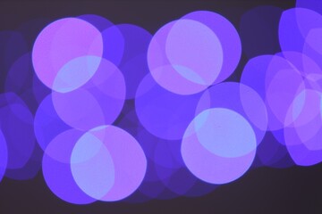 Blurred view of colorful lights on black background, bokeh effect