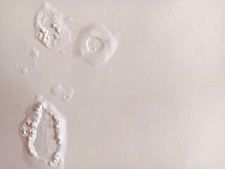 Abstract texture of paint blisters or bubbles on a white wall.