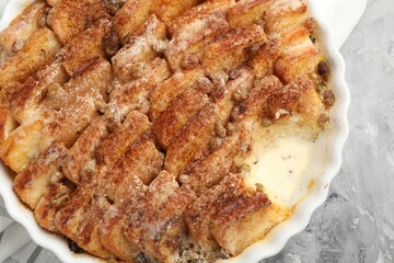 Delicious bread pudding with raisins and cinnamon on grey table, top view
