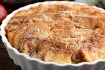 Delicious bread pudding with raisins and cinnamon on wooden table, closeup
