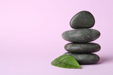 Stack of rocks on lilac background, space for text. Harmony and life balance