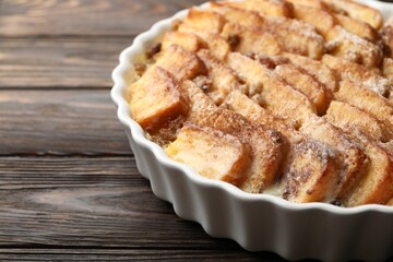 Delicious bread pudding with raisins and cinnamon on wooden table, closeup