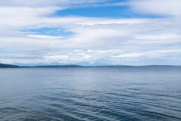 Ocean view with distant coastline and cloudy sky.