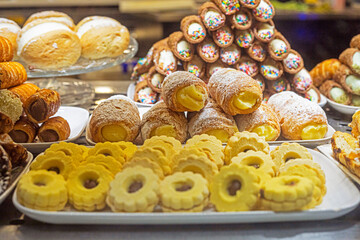 tubes and cookies with cream and chocolate, caramel and jam on the display case. Italian desserts, Traveling around Europe
