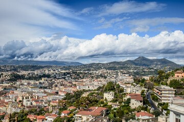 Scenic view of Nice, France with a backdrop of mountains and a partly cloudy sky.