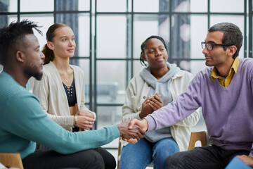 young people shaking hands in a circle of like-minded people