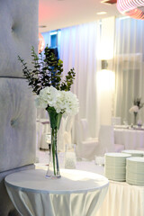 White flowers on the table in a glass vase as decoration