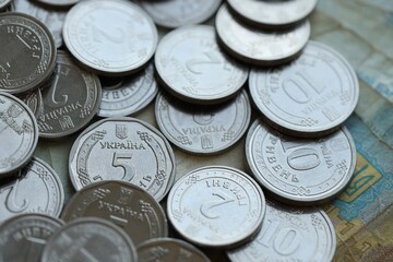 Ukraine money coins lying on mixed hryvnia banknotes, background.