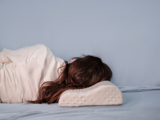 Woman sleeping on her back with an orthopedic pillow. Memory foam pillows are durable, retaining...