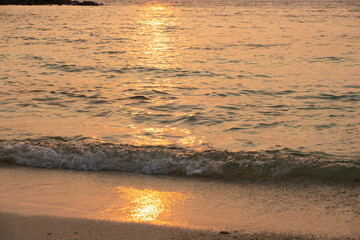 Beach sand background for summer vacation concept. The nature of the beach and the summer sea with the soft sunlight hitting the sand. The sea sparkles against the sunset sky.	
