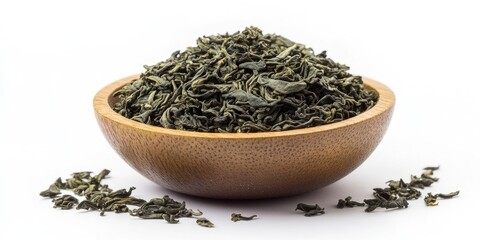 Fototapeta premium Dried green tea leaves in a wooden bowl with scattered leaves against a white background, showcasing earthy tones and natural textures.
