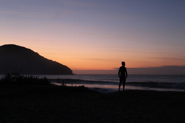 silhueta de homem em nascer do sol na praia 