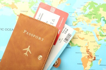 Passport with tickets on world map, top view