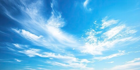 Vibrant blue sky with wispy white clouds creating a serene backdrop symbolizing freedom and tranquility in a bright daylight scene
