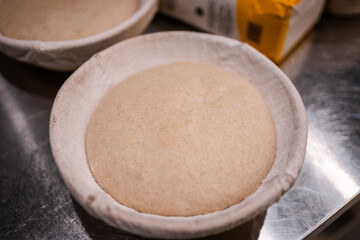 wheat bread in a fabric basket fits, ripens before baking, yeast bread in the bakery kitchen, baking preparation