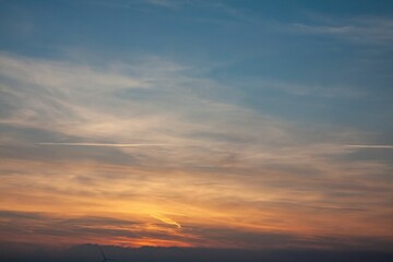 Serene sunset sky with soft clouds and vibrant colors, creating a tranquil atmosphere