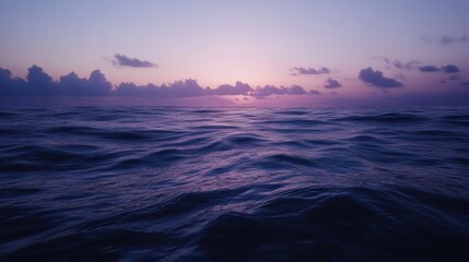 Fototapeta premium Serene ocean sunset with purple hues and gentle waves.