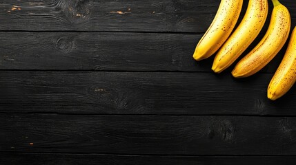 Ripe bananas arranged on a black wooden tabletop showcasing texture and color contrast for culinary or lifestyle themes