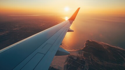 Aerial view of sun setting over ocean with sandy coastline and airplane wing in frame creating a serene travel atmosphere