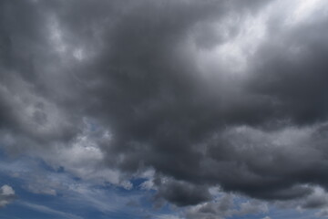 Photography of dark black storm clouds with a rainy atmosphere on a gray sky background. Suitable for backgrounds.