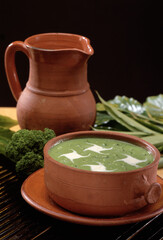 Spinach cream on rustic bowl and ingredients on rustic background.