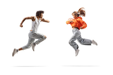 Full length profile shot of an african american male dancer and asian female jumping