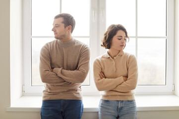 Bad misunderstanding, sad worried young spouses looking opposite, not talking after quarreling,...