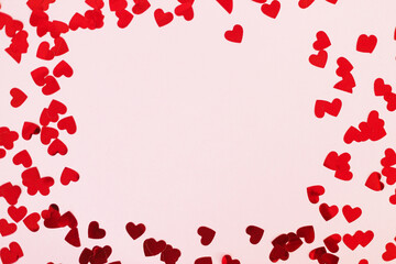 Happy valentines day. Stylish red hearts confetti frame on pink background flat lay with copy space. Love background