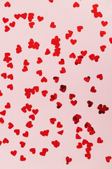 Happy valentines day. Stylish red hearts confetti on pink background flat lay. Love background