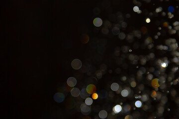 Abstract bokeh lights with colorful circles on dark background, creating a dreamy and festive...
