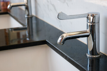 sleek chrome faucet installed on a polished black marble counter