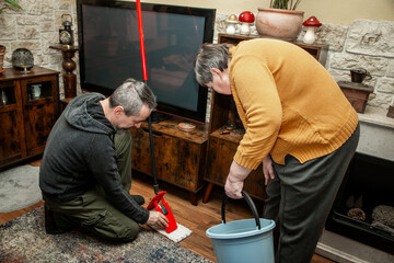 Two people, one of them with diasability, do house cleaning together