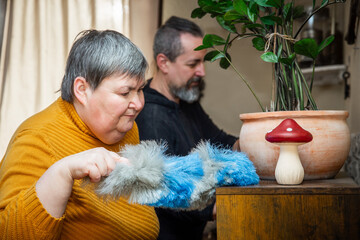 Two people, one of them with diasability, do house cleaning together