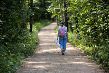 Walking along a peaceful forest path surrounded by lush greenery on a sunny day
