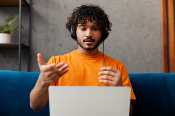 Employee operator Indian business man he wear orange casual clothes set microphone headset for...