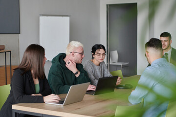 A diverse multiethnic business team engages in a collaborative meeting, discussing strategies and solutions in a modern office setting