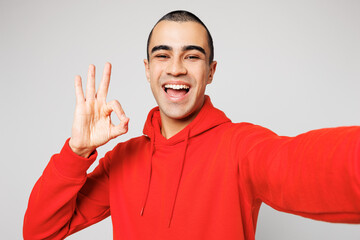 Close up young middle eastern man he wear red hoody casual clothes doing selfie shot pov on mobile...