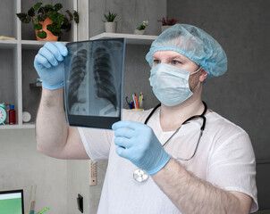 Tuberculosis. Oncology of the lungs. A doctor with a stethoscope looks at an x-ray of the lungs, a medical worker in a hospital analyzes a person's illness. The office of the radiographer