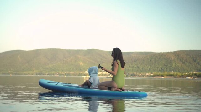 two people paddle kayaks across a calm lake