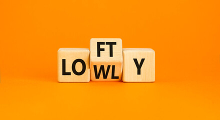 Lofty or lowly symbol. Concept words Lofty Lowly on wooden block. Beautiful orange table orange background. Business lofty or lowly concept. Copy space.