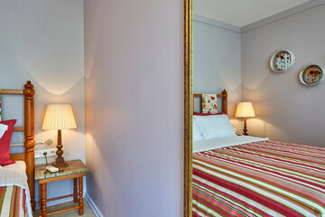 Old hotel room interior style with bed mirror carpet design.