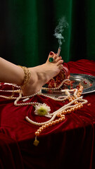 Female foot with golden accessories and green expensive ring, holding cigarette, surrounded by...