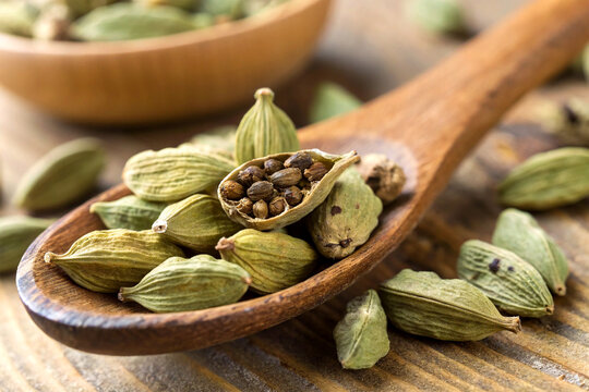 Close-up of cardamom pods in a wooden spoon
