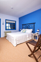 Blue hotel room interior concept, white bed and bathroom style.