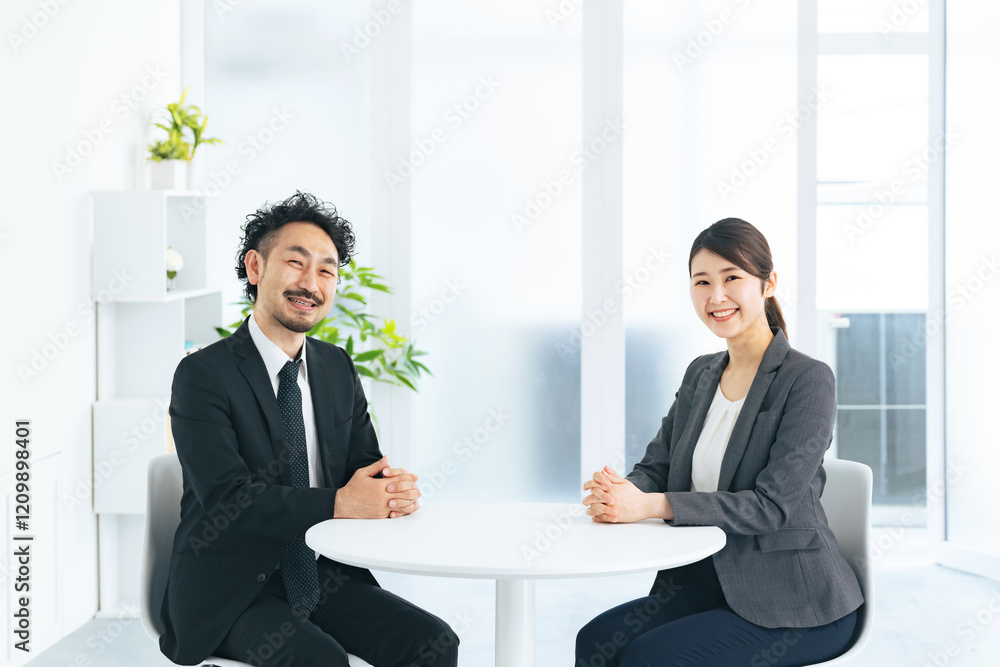 Poster ビジネス、オフィス、ビジネスパーソン、男性、女性、日本人、スタッフ、笑顔、カメラ目線、受付、ビジネスマン、ビジネスウーマン、職場、テーブル、座る、若い、仕事、接客、店員、店舗、ショップ、営業、人材、サ